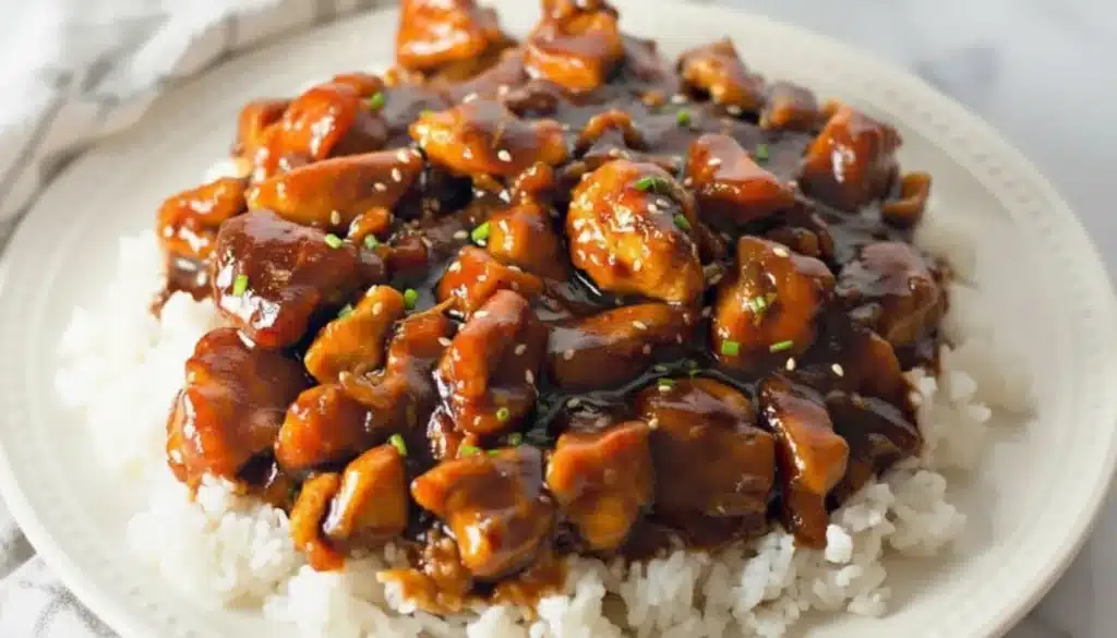 Sticky bourbon chicken garnished with sesame seeds and green onions