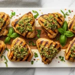 Platter of juicy Grilled Chicken Thighs with Garlic Marinade garnished with fresh parsley and lemon wedges.